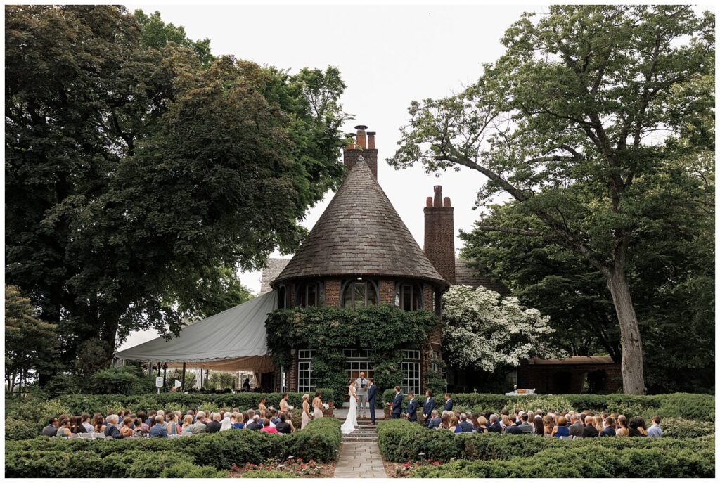 Wide angle of a garden ceremony at Greenville Country Club with all the guests looking at the bride and groom as they say "I do." 