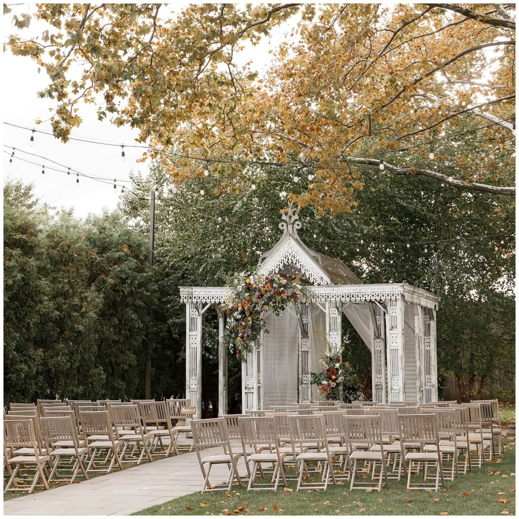 Terrain at Styers ceremony location with rustic wooden chairs and colorful florals set up for an intimate, fall time wedding